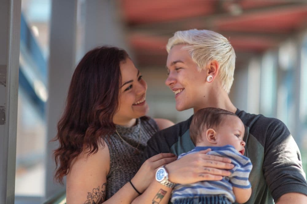 LGBTQ+ couple holding their baby